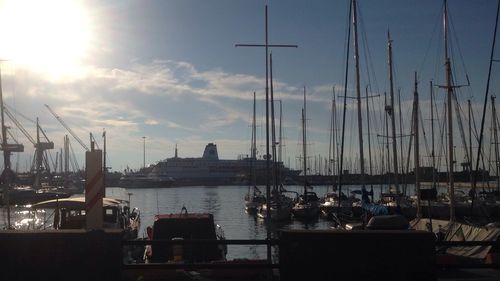 Boats moored in calm sea against sky on sunny day