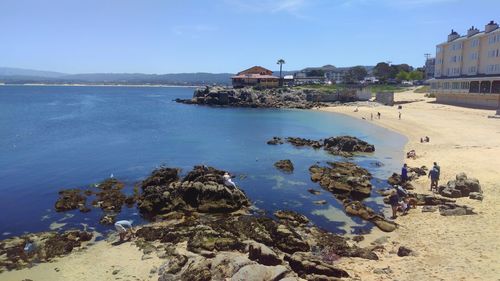 Scenic view of sea by buildings against sky