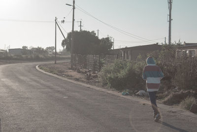 Rear view of man walking on road