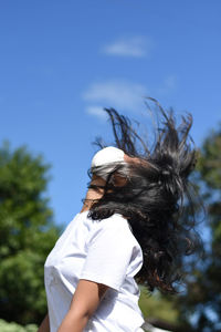 Midsection of woman standing against sky