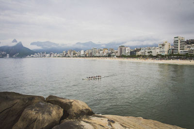 Scenic view of sea by city against sky