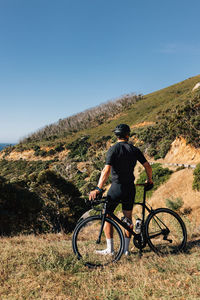 Rear view of man riding bicycle on mountain