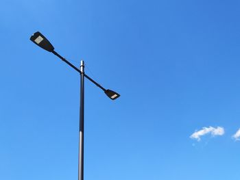 Low angle view of street light against blue sky