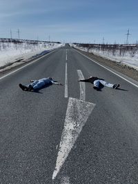 High angle view of man lying down on road