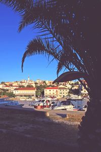 View of town by sea against clear blue sky