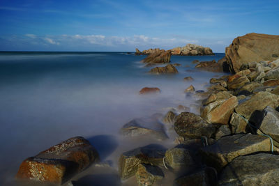 Rocks on beach against sky