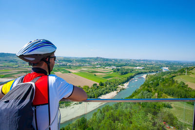 Man standing on mountain against clear blue sky