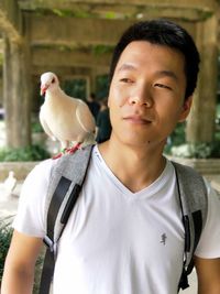 Close-up of man with bird against blurred background