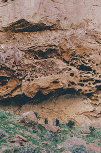 Low angle view of people hiking by rock formations