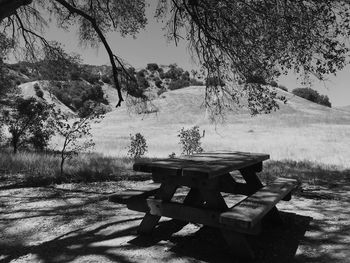 Picnic table on field against hills