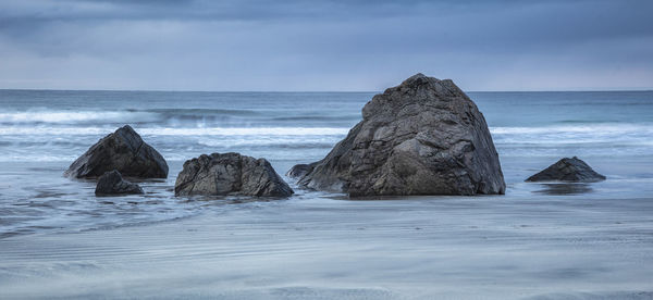 Rocks in sea against sky