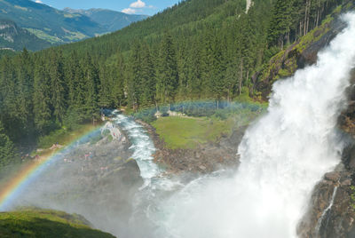 Scenic view of krimml waterfalls against tree mountain