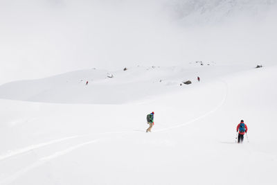 People skiing on snowcapped mountain