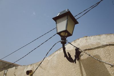 Low angle view of electric lamp against clear sky