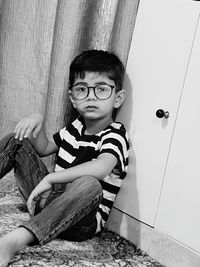 Portrait of boy sitting on floor at home