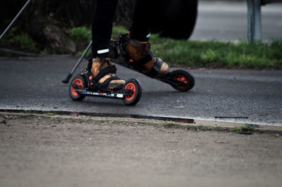 Low section of person roller skating on road