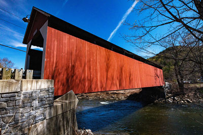 Building by river against blue sky