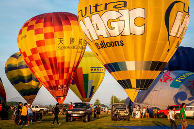 Multi colored hot air balloons on field against sky