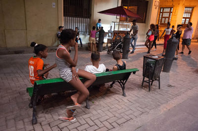 People sitting on chair in city