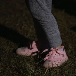 Low section of woman standing on field