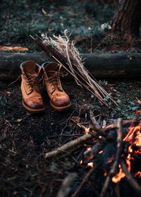 View of shoes by bonfire in forest