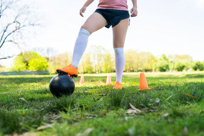 Low section of woman with ball on field
