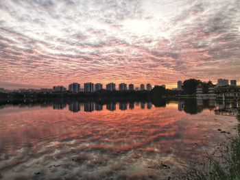 Reflection of buildings in lake at sunset