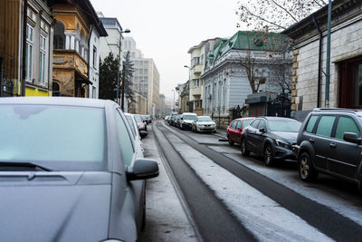 Cars on road by buildings in city