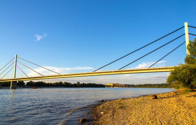 Bridge over river against clear blue sky