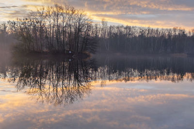 Scenic view of lake against sky at sunset