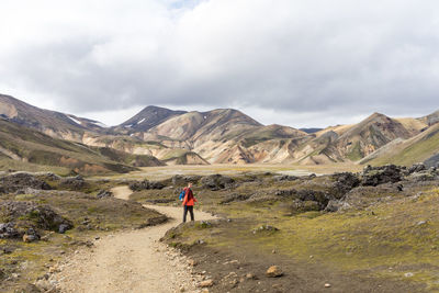 Male hiker walking down the empty rocky trail in iceland