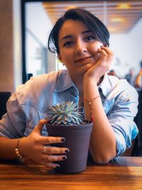 Portrait of young woman sitting on table