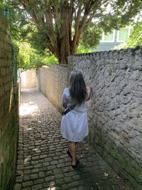 Portrait of young woman standing against wall