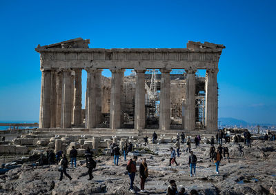 Tourists at historical building against clear sky