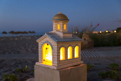 Illuminated building against sky at dusk