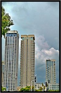 Low angle view of buildings against cloudy sky