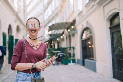 Portrait of smiling man standing on mobile phone