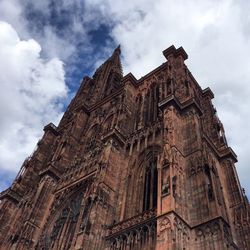 Low angle view of old church against cloudy sky