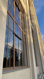 Low angle view of glass building against sky