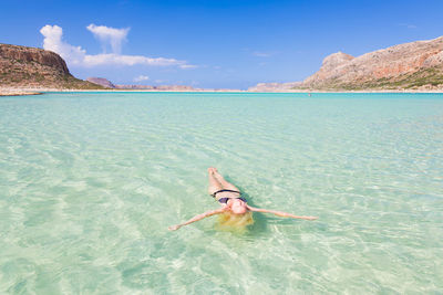 Woman in swimming pool against sea