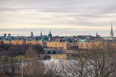 River by buildings in city against sky