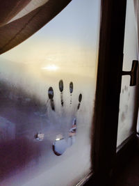 Close-up of fingerprints on wet window