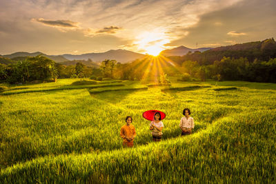 Scenic view of grassy field against sky during sunset