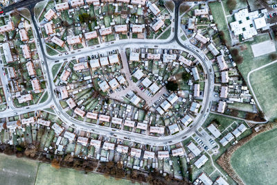 Aerial view above the snow covered streets and rooftops of a suburban street with cul de sac