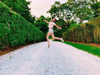 Full length of woman jumping on plant