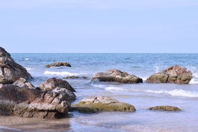 Rocks on beach against clear sky