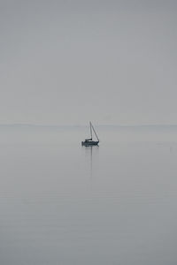 Sailboat in sea against clear sky