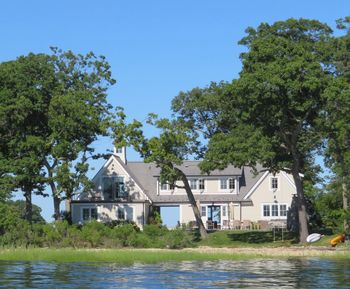 Building by river against clear blue sky