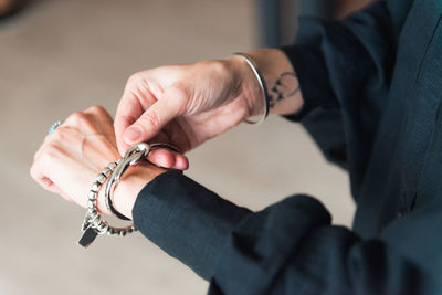 Fashion details - bracelets on the hand of a stylish woman with tattoo