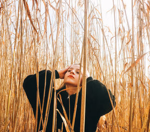 Young woman looking away while standing on land